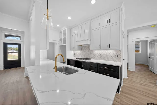 a kitchen with stainless steel appliances granite countertop a sink a stove and a refrigerator