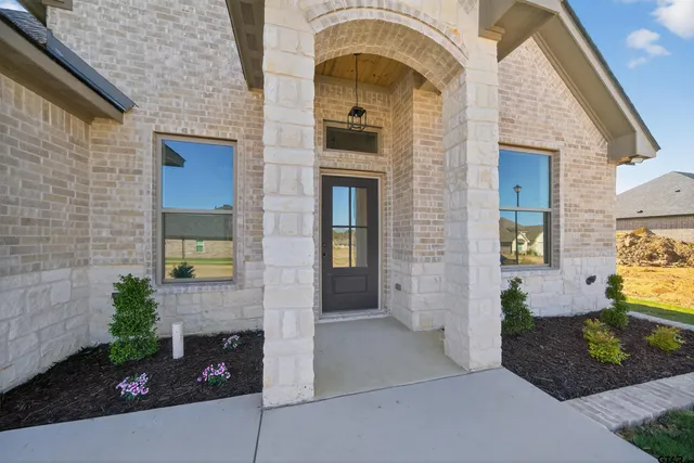 a view of a brick house with potted plants