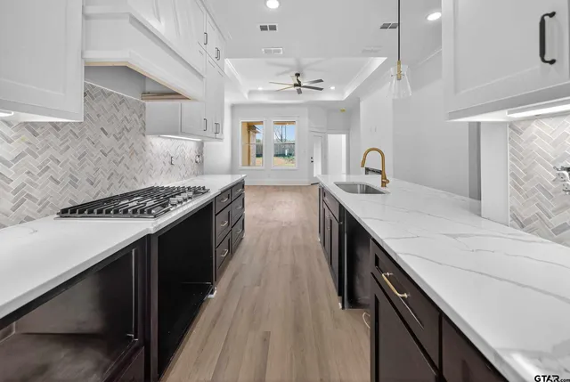 a kitchen with granite countertop a sink stove and cabinets