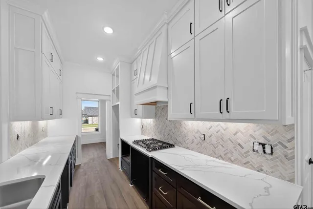 a kitchen with granite countertop a sink stove and cabinets