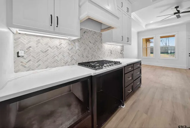 a kitchen with granite countertop a stove and a wooden floor