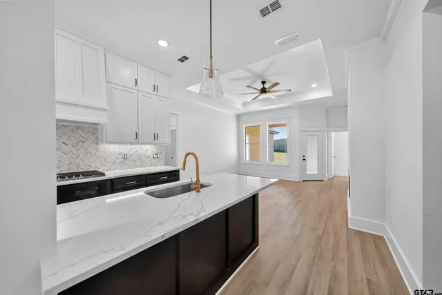 a kitchen with kitchen island a sink appliances and cabinets