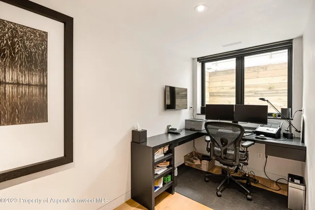 a view of a workspace with furniture and a window