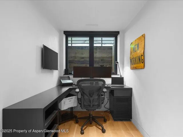 a work room with furniture and a flat screen tv