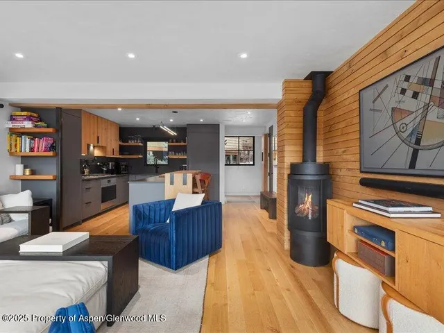 a living room with stainless steel appliances furniture and a kitchen view
