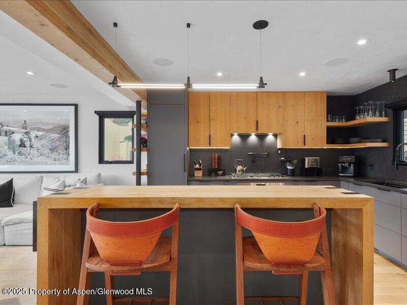 100 North 8th Street, Unit 15 Aspen, CO 81611 - Photo 7 of 27 a large kitchen with stainless steel appliances granite countertop a sink a stove a dining table and chairs