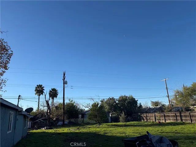 a view of a grassy field with trees in the background