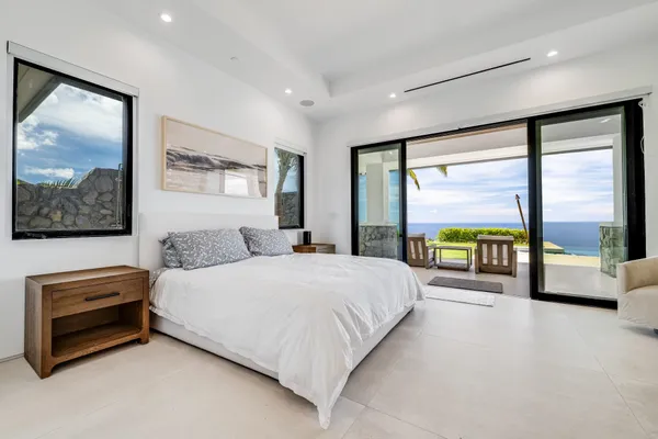 a bedroom with furniture and a large window