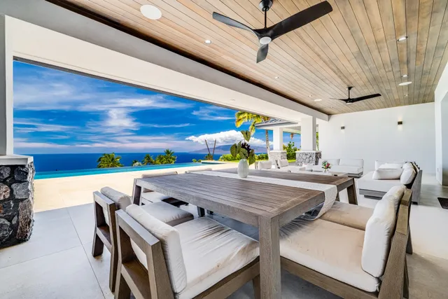 a view of a dining hall with furniture and a kitchen view