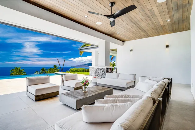 a living room with patio furniture and a potted plant