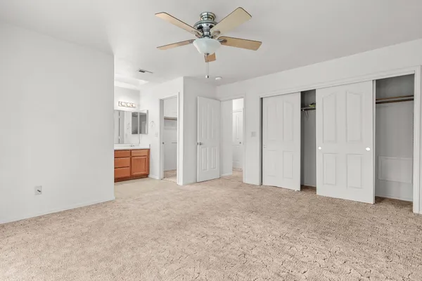 a view of a livingroom with a ceiling fan a kitchen space a ceiling fan and a window