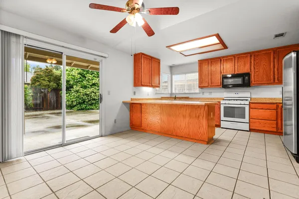 a kitchen with stainless steel appliances granite countertop a stove a sink and a microwave