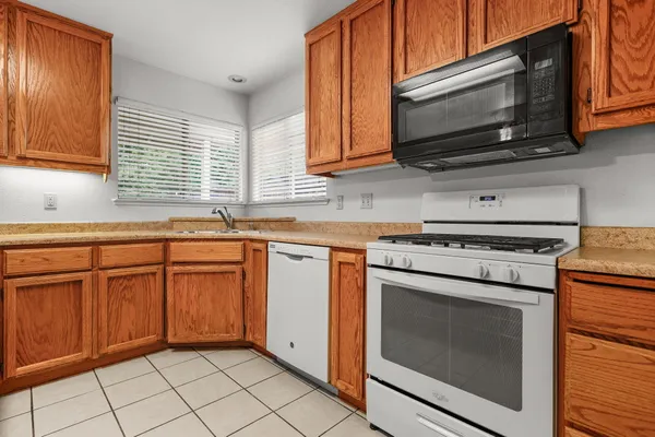 a kitchen with granite countertop cabinets stainless steel appliances and a sink