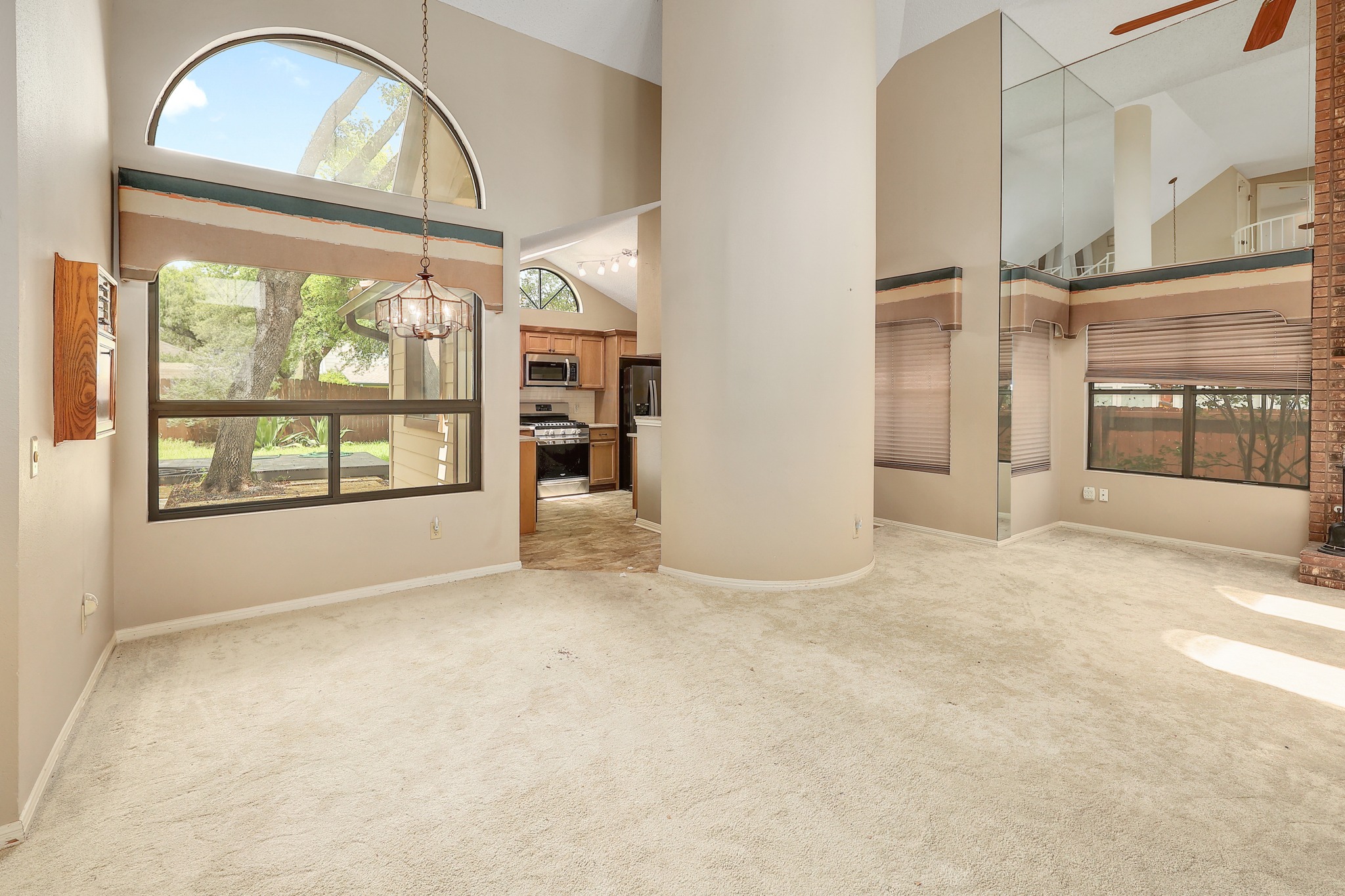 2202 Warfield Way Austin, TX 78728 - Photo 7 of 32 Natural illumination fills this room, showcasing soaring ceilings and a charming chandelier.