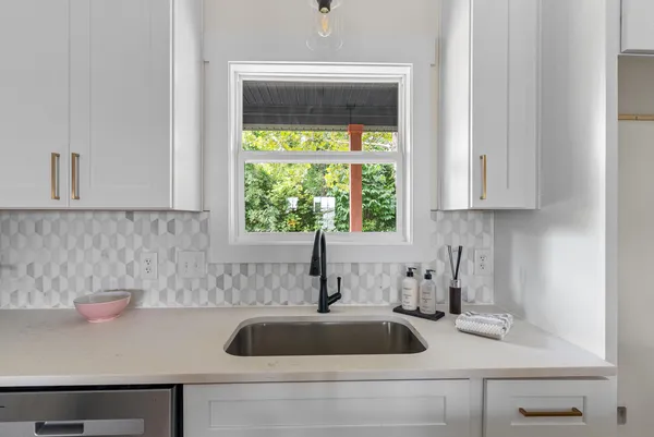 a kitchen with stainless steel appliances white cabinets and a stove top oven