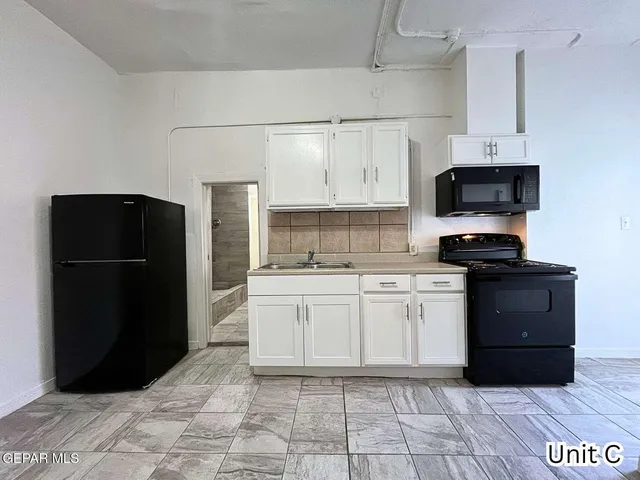 a kitchen with a refrigerator and a stove