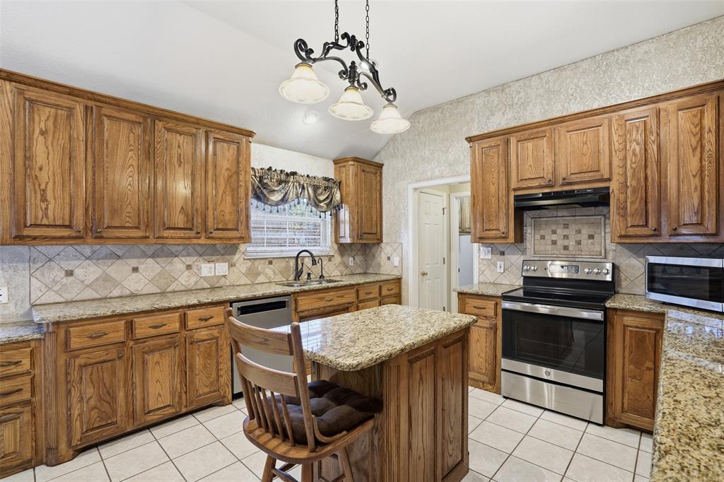 231 Bluff View Court Aledo, TX 76008 - Photo 26 of 34 a kitchen with granite countertop stainless steel appliances and wooden cabinets