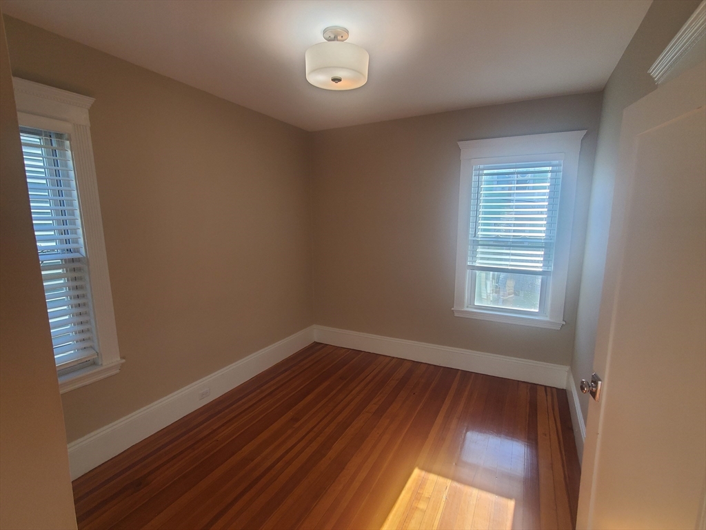 14 North Munroe Terrace, Unit 2 Boston, MA 02122 - Photo 12 of 19 a view of an empty room with wooden floor and a window