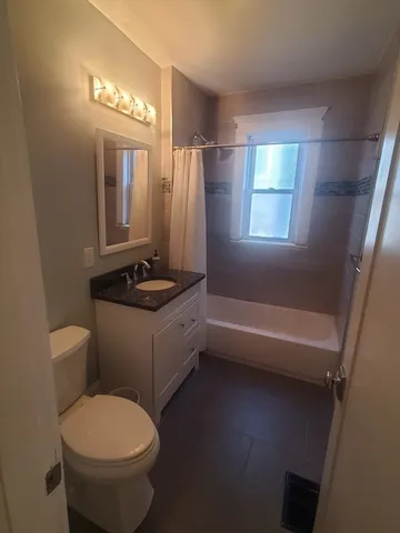 a bathroom with a granite countertop toilet sink and mirror