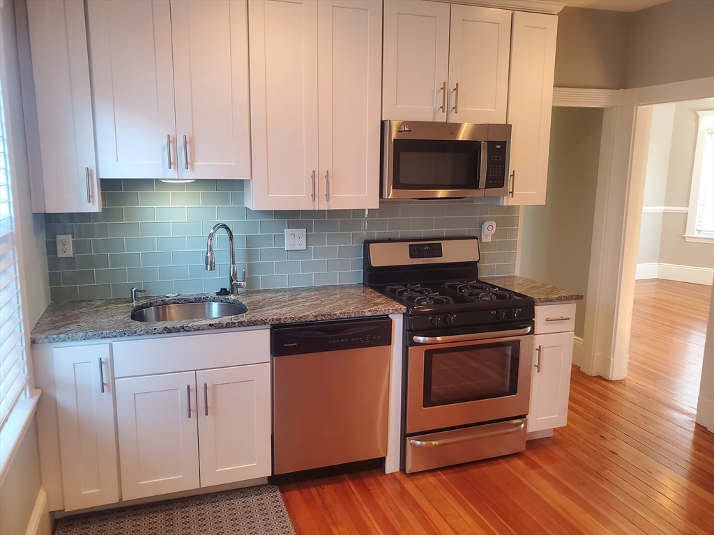 14 North Munroe Terrace, Unit 2 Boston, MA 02122 - Photo 2 of 19 a kitchen with granite countertop a stove and a sink