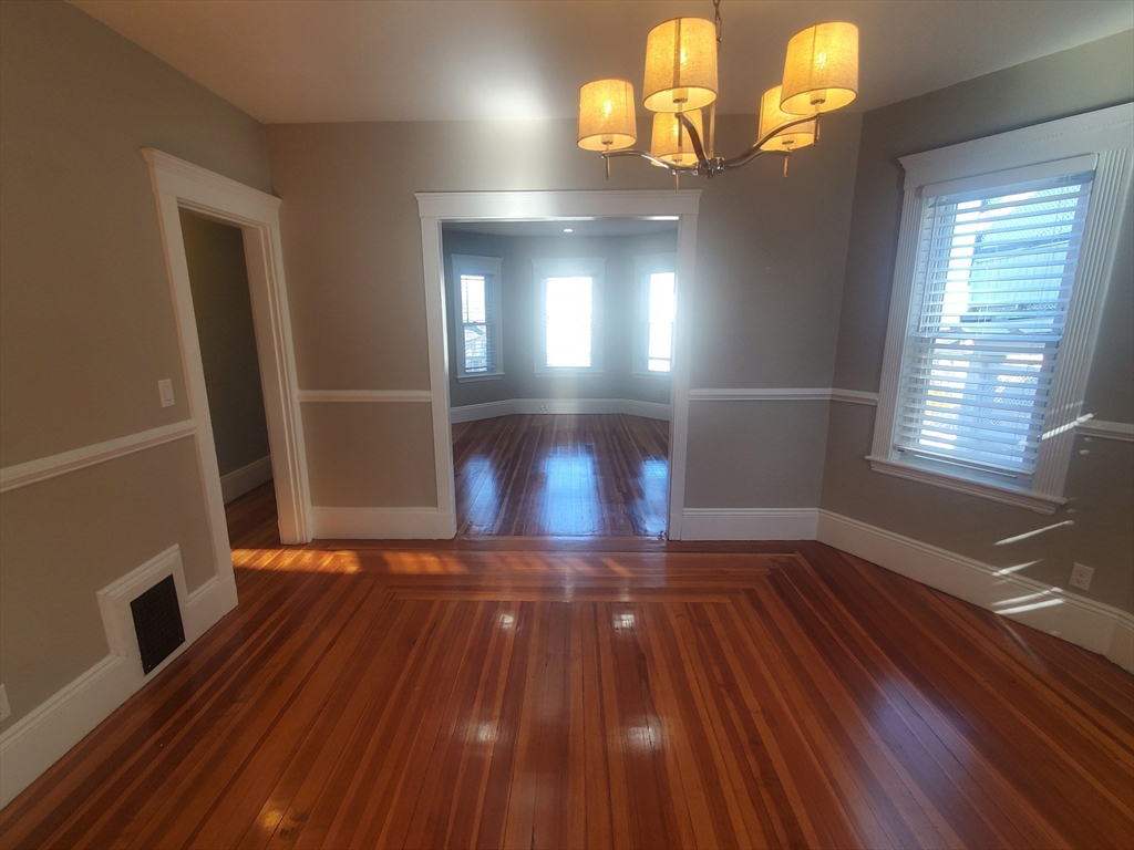 14 North Munroe Terrace, Unit 2 Boston, MA 02122 - Photo 8 of 19 a view of an empty room with wooden floor and a window