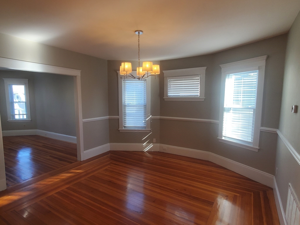 14 North Munroe Terrace, Unit 2 Boston, MA 02122 - Photo 9 of 19 an empty room with wooden floor and windows