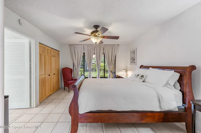 a bedroom with a bed and a large window