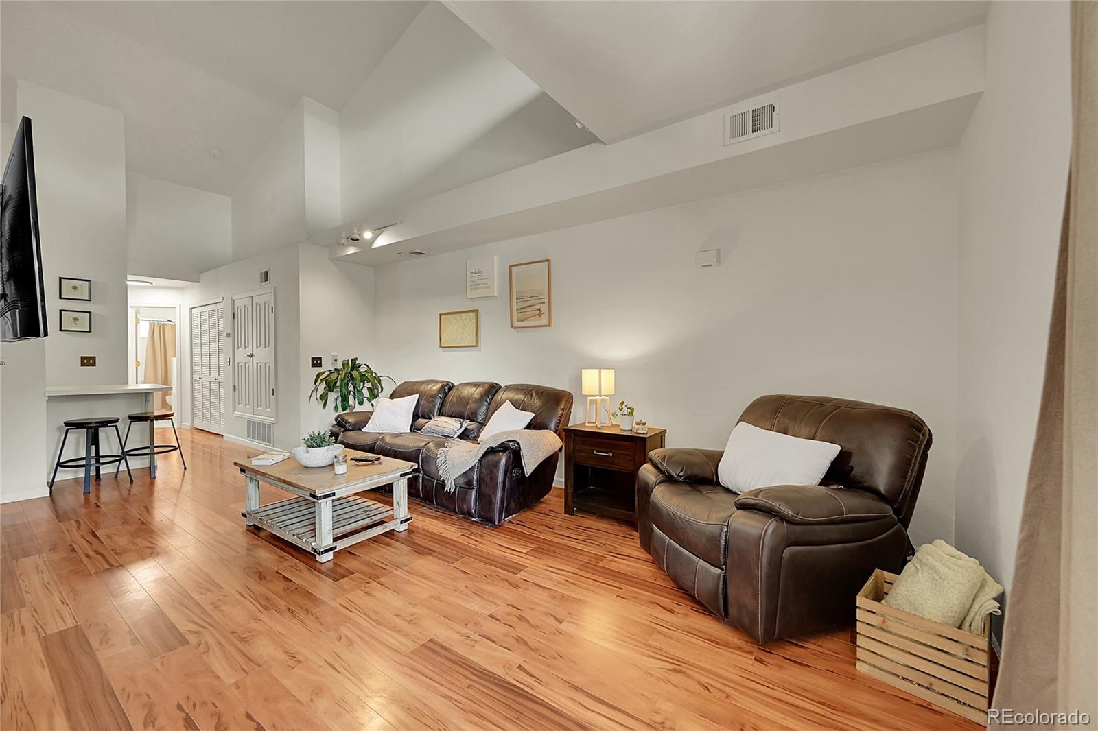 18152 East Flora Place, Unit I Aurora, CO 80013 - Photo 1 of 27 a living room with furniture wooden floor and a flat screen tv