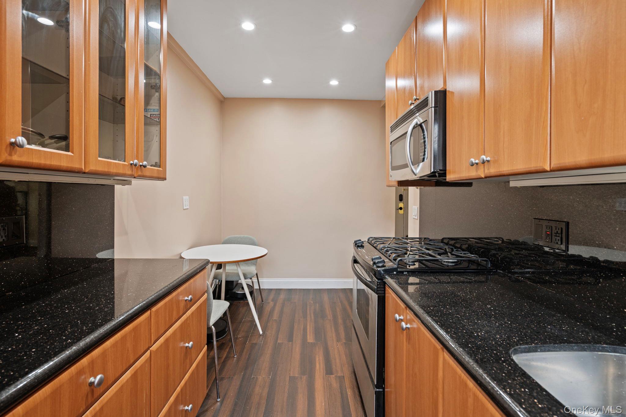 77-15 Ditmars Boulevard, Unit B2 Queens, NY 11370 - Photo 15 of 24 a kitchen with stainless steel appliances granite countertop a sink a stove counter space and cabinets