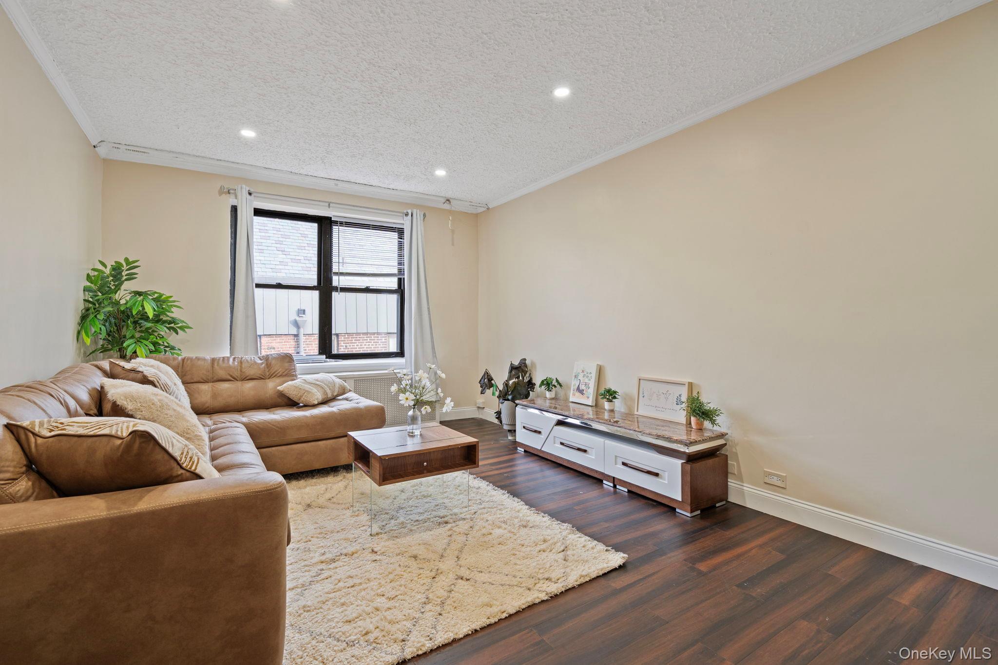 77-15 Ditmars Boulevard, Unit B2 Queens, NY 11370 - Photo 4 of 24 a living room with furniture and a wooden floor