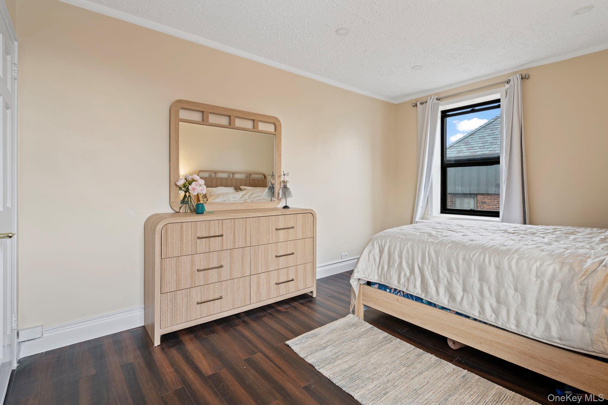 77-15 Ditmars Boulevard, Unit B2 Queens, NY 11370 - Photo 10 of 24 a bedroom with a bed and a dresser