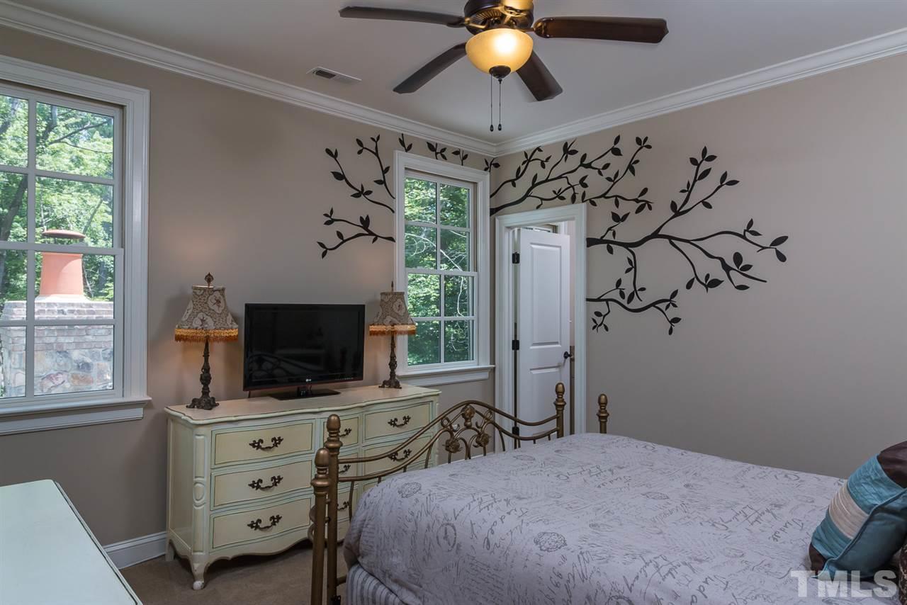 8841 Stage Ford Road Raleigh, NC 27615 - Photo 13 of 25 a bedroom with a bed and a flat tv screen on dresser