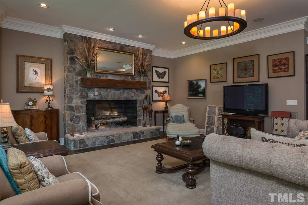 8841 Stage Ford Road Raleigh, NC 27615 - Photo 5 of 25 a living room with furniture a fireplace and a flat screen tv