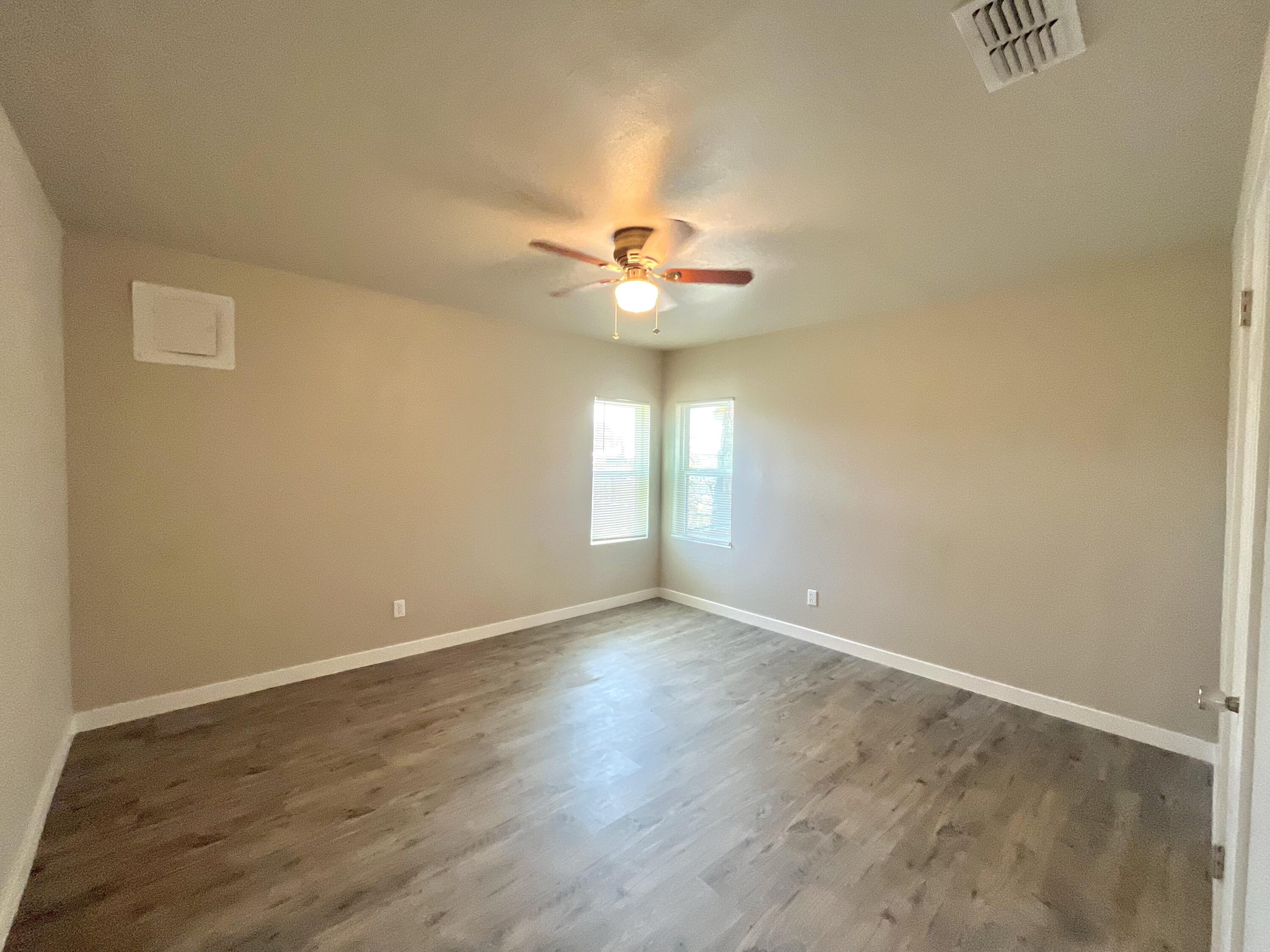 1510 East 10th Street Lubbock, TX 79403 - Photo 5 of 6 an empty room with a window and a ceiling fan