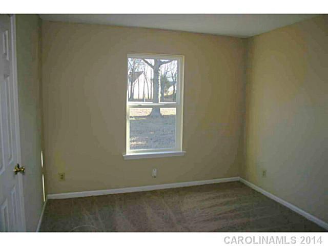 3317 Sandy Porter Road Charlotte, NC 28273 - Photo 9 of 12 a view of an empty room with wooden floor and a window