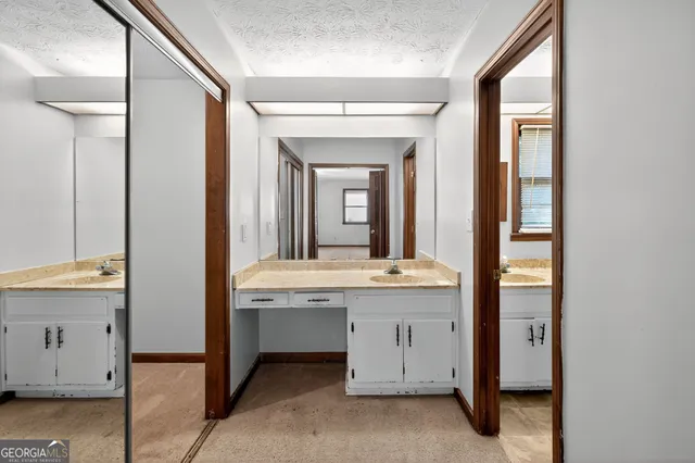 a bathroom with a granite countertop toilet a sink and a mirror