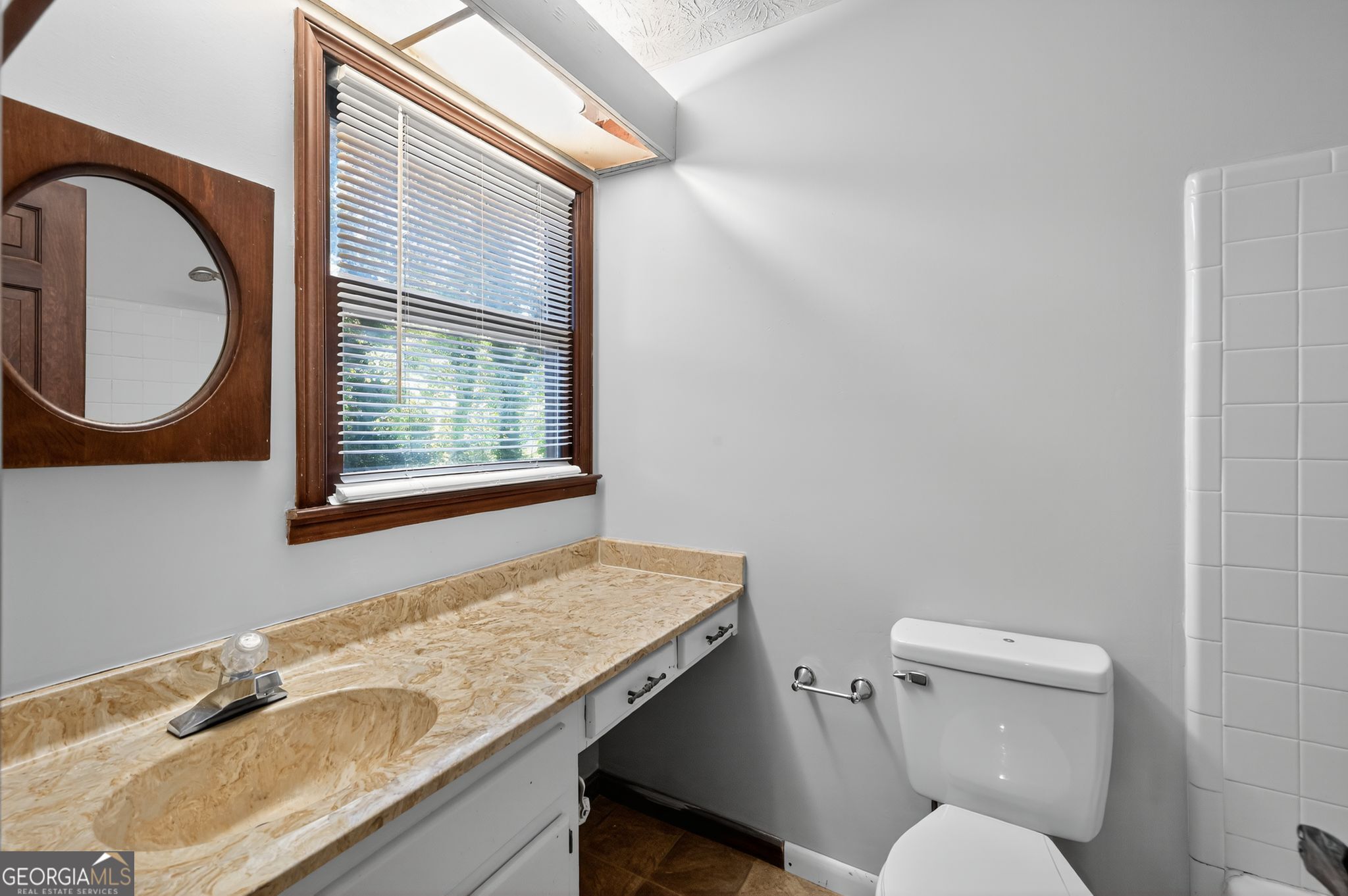 1378 Stoneleigh Hill Road Lithonia, GA 30058 - Photo 16 of 32 a bathroom with a granite countertop toilet a sink and a mirror