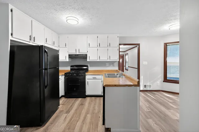 a kitchen with white cabinets and stainless steel appliances
