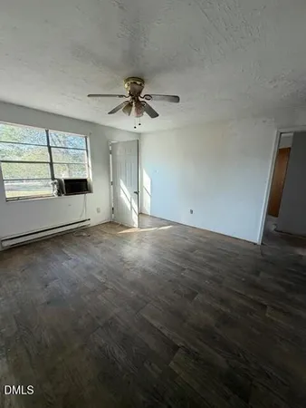 an empty room with windows and ceiling fan