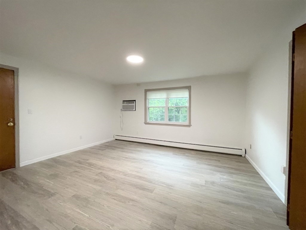4 Dodge Road, Unit 1A10 Rowley, MA 01969 - Photo 2 of 5 an empty room with wooden floor and windows