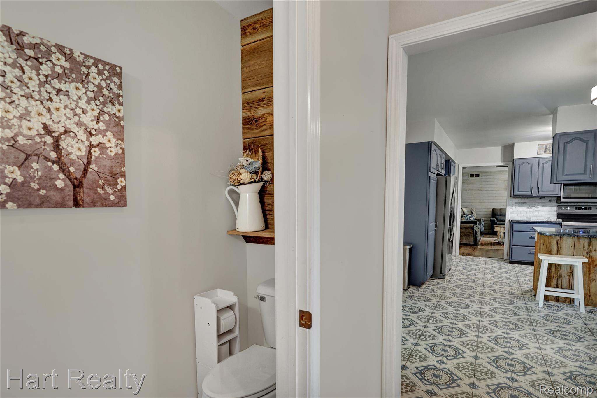 7167 Brown School Road North Branch, MI 48461 - Photo 21 of 51 Powder room featuring a white toilet and a wood-paneled accent wall with a floating shelf