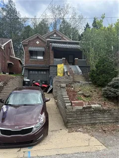 a view of a house with cars parked
