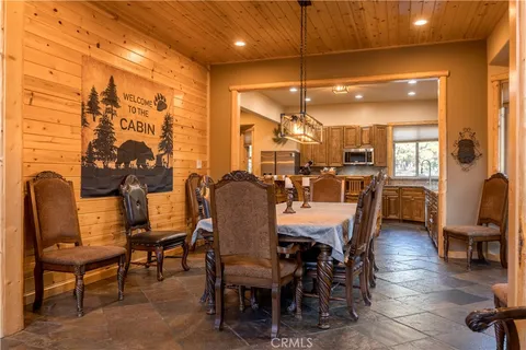 a dining room with furniture a chandelier and wooden floor