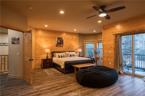 a large bedroom with a bed and wooden floor