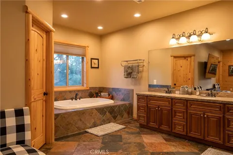 a bathroom with a double vanity sink mirror and bathtub