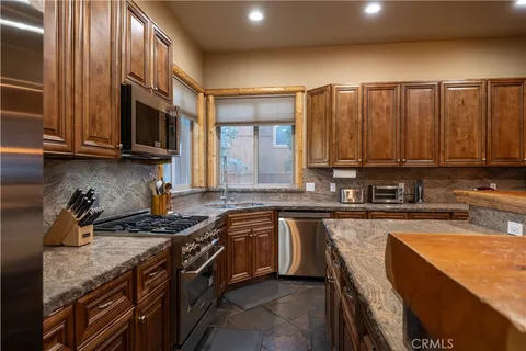 a kitchen with stainless steel appliances granite countertop a stove a sink and a microwave