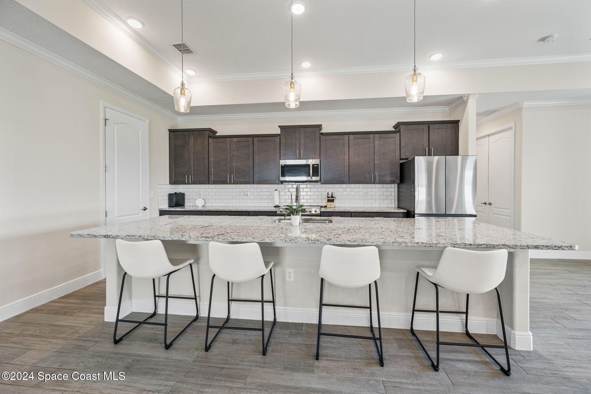 3500 Rixford Way Palm Bay, FL 32909 - Photo 8 of 55 a kitchen with granite countertop a table chairs stove a sink and a refrigerator