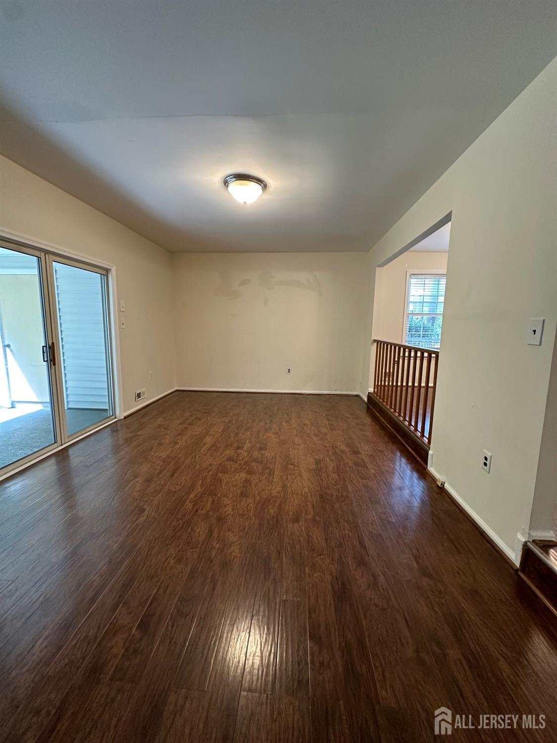 315 Constitution Circle North Brunswick, NJ 08902 - Photo 3 of 9 an empty room with wooden floor and windows