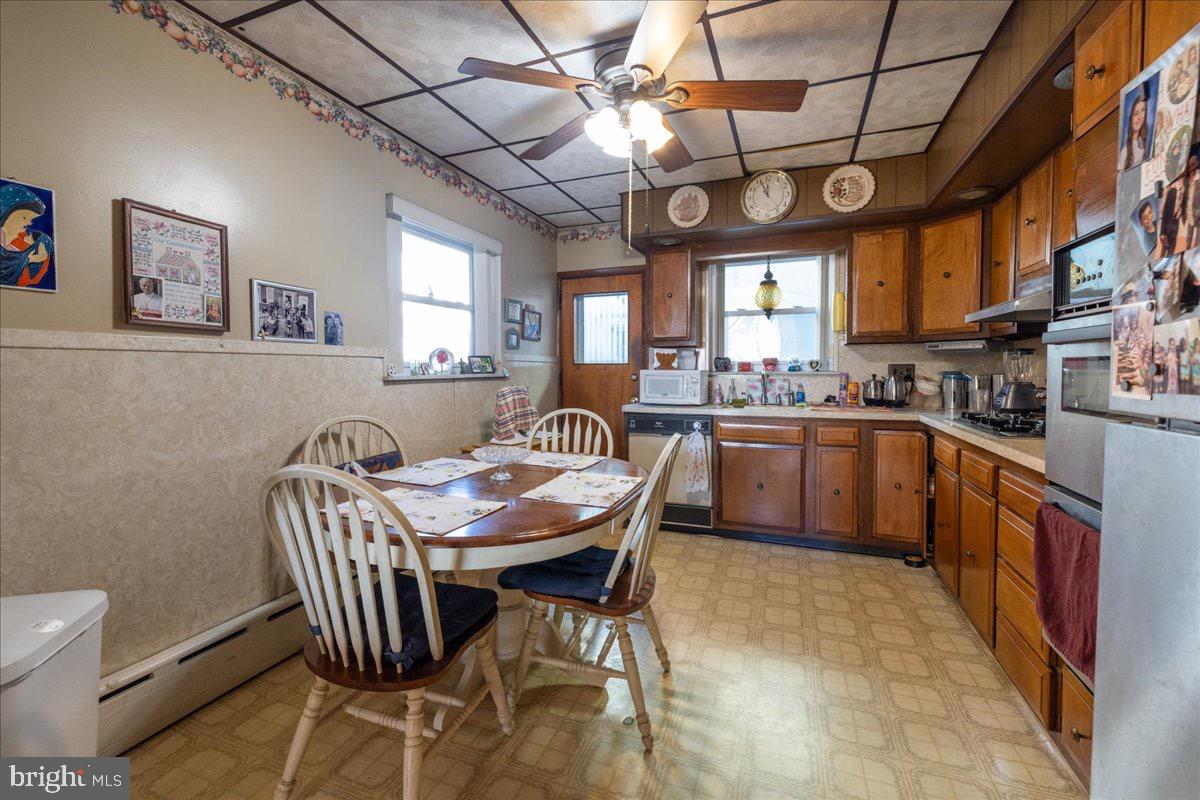 1229 Jackson Street Philadelphia, PA 19148 - Photo 9 of 29 a kitchen with stainless steel appliances granite countertop a sink a stove a dining table and chairs with wooden floor