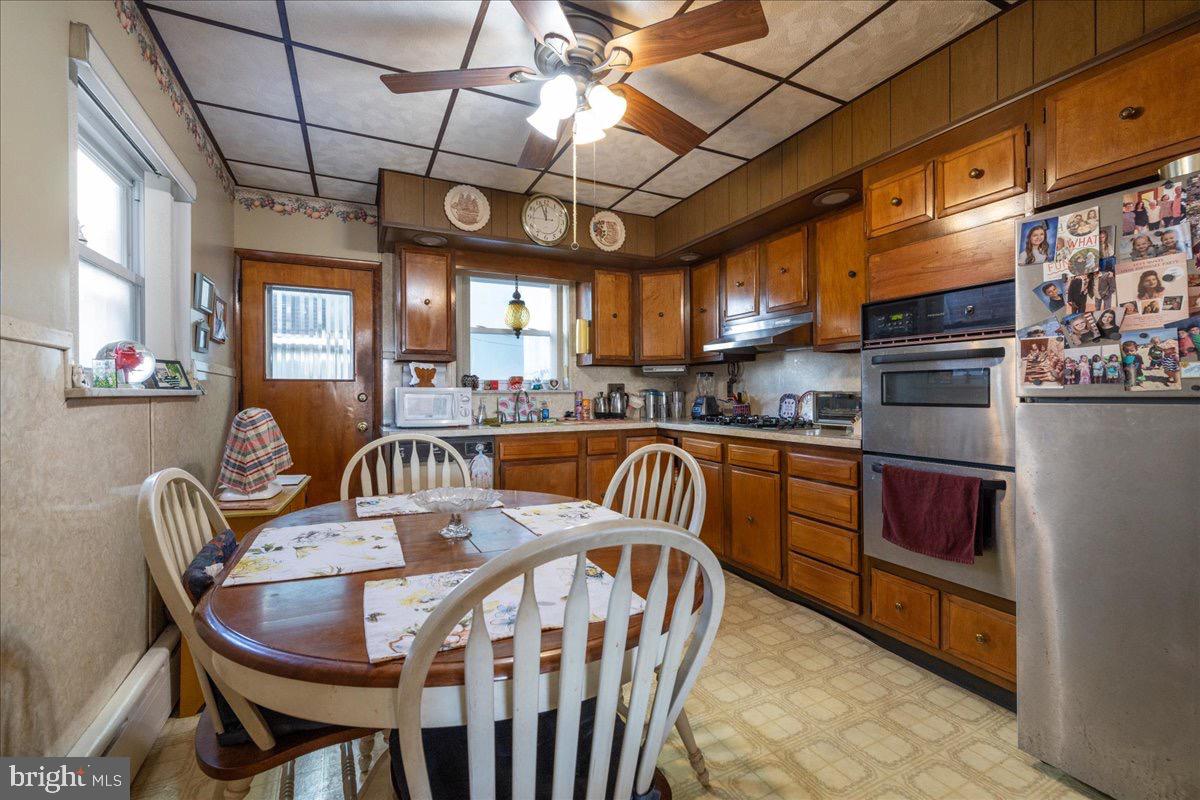 1229 Jackson Street Philadelphia, PA 19148 - Photo 10 of 29 a kitchen with stainless steel appliances granite countertop a sink a stove a dining table and chairs with wooden floor